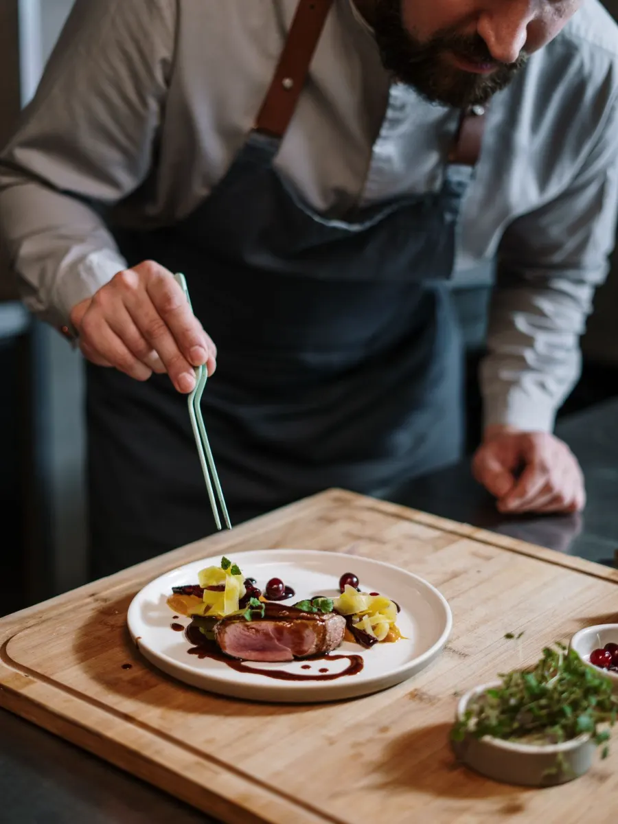 La cheffe dresse une assiette en cuisine